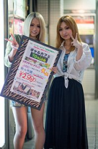 Two high school gyaru girls with their hair died blonde and uniform white shirt tied up stylishtically