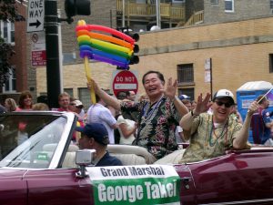 A Trekker displaying the Vulcan salute white holding a rainbow flag in support of gay rights.