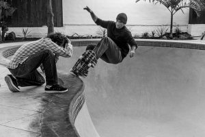 A professional skateboarder, Lance Mountain, skating in an empty pool