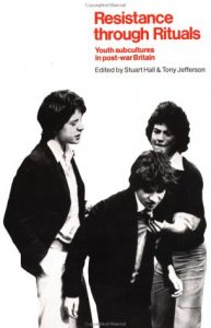 Book cover of Resistance through Rituals by Hall and Jefferson. 3 Men dressed in suits, one leaning over slightly as the other grabs his shoulder aggressively. White background.
