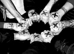Straight edgers showing X symbols on fists in solidarity