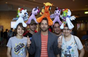 Five people with My Little Pony plush animals sitting on their heads