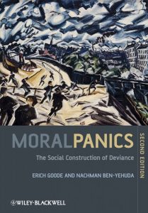 A book cover of Moral Panics the Social Construction of Deviance with people running down a mountain toward a village. The picture uses dark colors and is drawn abstractly. 