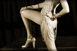 Burlesque performer leg up on table