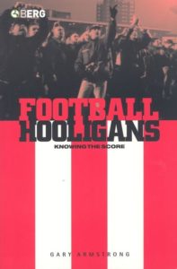 The cover to Gary Armstrong's book, Football Hooligans: Knowing the Score, which has red and white stripes with a grey scale depiction of hooligans