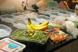 Food packages and plastic containers laid out on a counter before meal preparation
