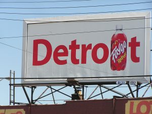 A billboard with the word Detroit with the "I" replaced with an image of Faygo soda.