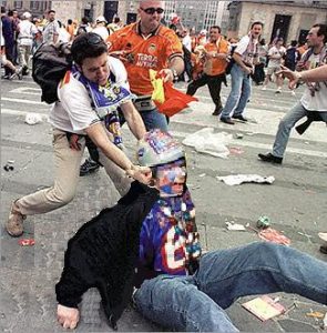 One hooligans punches another in the streets during a riot between two opposing teams