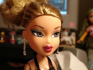 A headshot of a Bratz doll with heavy makeup and jewelry.