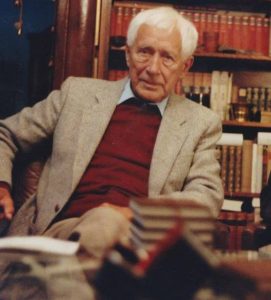 German thinker Ernst Junger, father of the word "psychonaut," sitting at a desk and surrounded by books.
