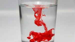 a drop of red food coloring diffuses in water