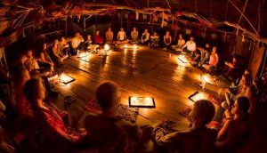 People sitting in a circle during an ayahuasca ceremony in Peru.